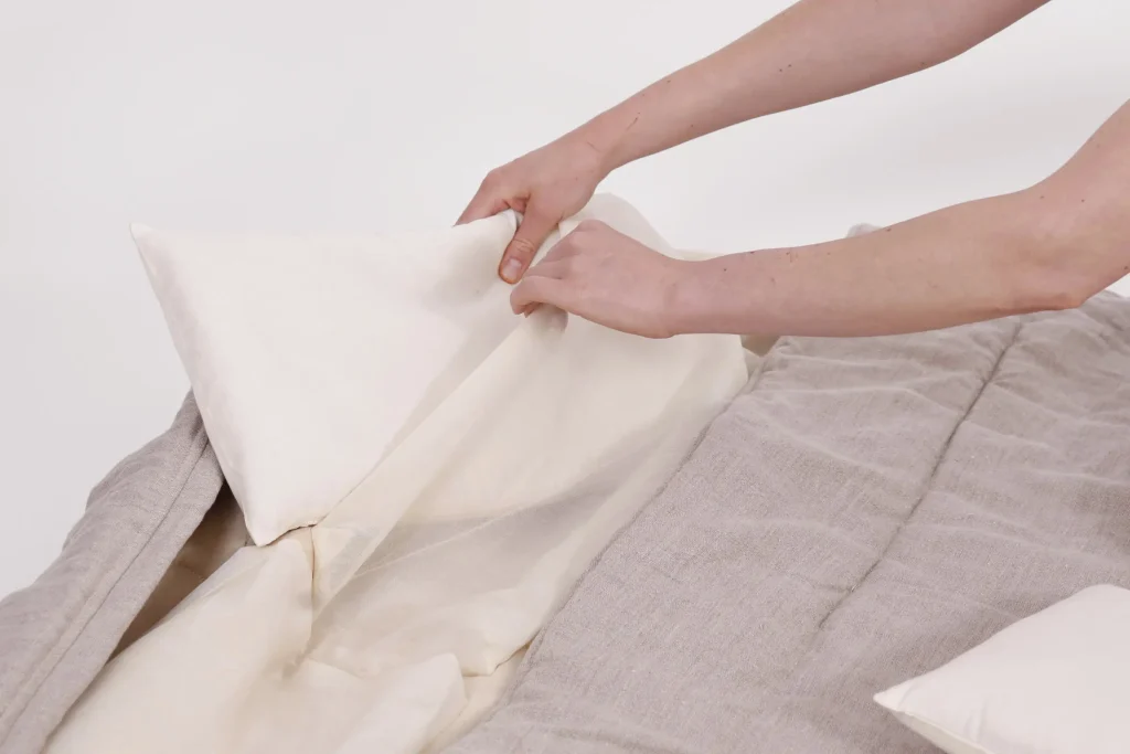 nomad-blog-duo-bag-3 hands inserting a pillow into a nomadheat sleeping bag pouch